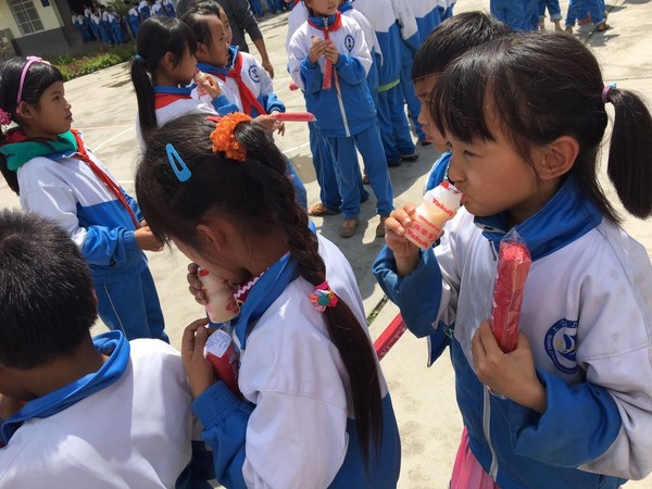 圖1：2016年山區(qū)的孩子們在品嘗養(yǎng)樂多，并收到志愿者帶來的禮物