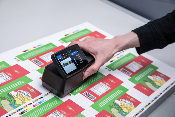 操作員使用eXact 2 分光光度儀在控制臺(tái)上測(cè)量樣張 操作員使用eXact 2 分光光度儀在控制臺(tái)上測(cè)量樣張