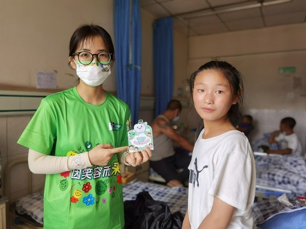 好來志愿者給孩子們講解并贈(zèng)送口腔小冊(cè)子